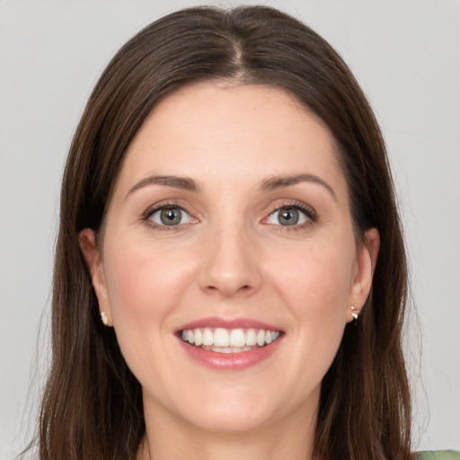 Joyful white young-adult female with long  brown hair and grey eyes