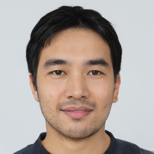 Joyful asian young-adult male with short  black hair and brown eyes