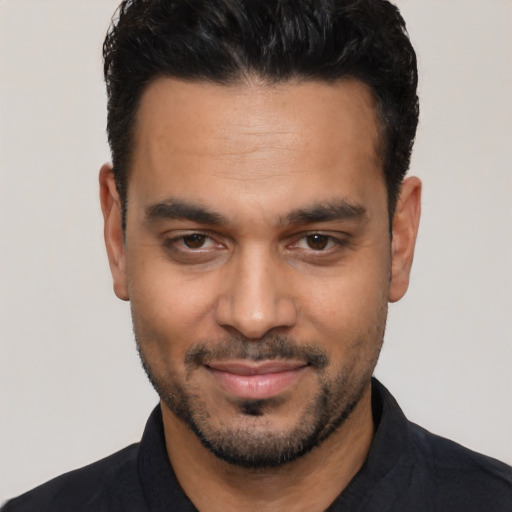 Joyful latino young-adult male with short  black hair and brown eyes