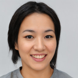 Joyful asian young-adult female with medium  black hair and brown eyes