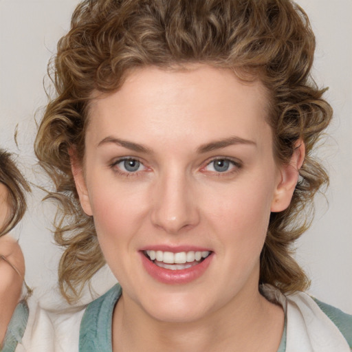 Joyful white young-adult female with medium  brown hair and blue eyes