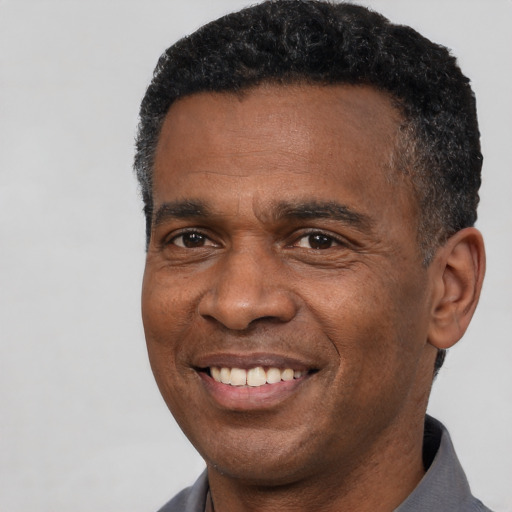 Joyful black adult male with short  black hair and brown eyes