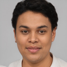 Joyful latino young-adult male with short  black hair and brown eyes