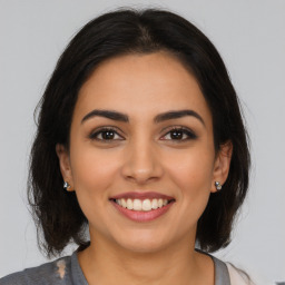 Joyful latino young-adult female with medium  brown hair and brown eyes