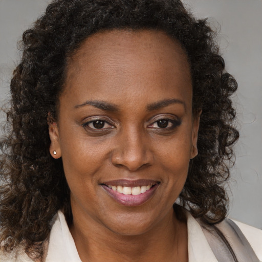 Joyful black adult female with medium  brown hair and brown eyes
