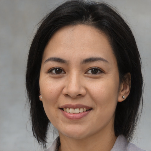 Joyful asian adult female with medium  brown hair and brown eyes