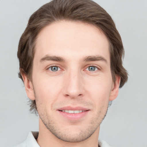 Joyful white young-adult male with short  brown hair and grey eyes