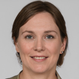 Joyful white adult female with medium  brown hair and grey eyes