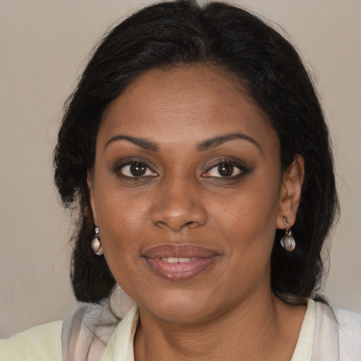 Joyful black adult female with medium  brown hair and brown eyes