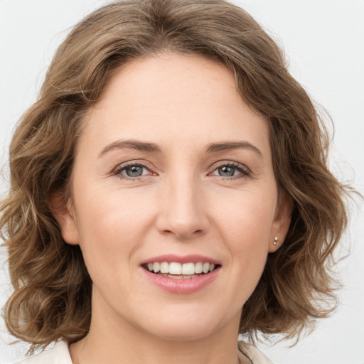 Joyful white young-adult female with medium  brown hair and green eyes