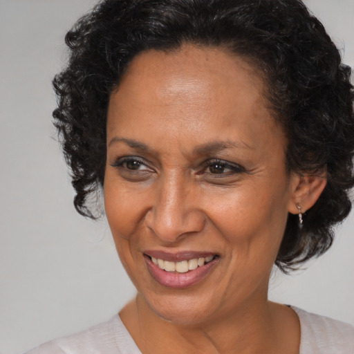 Joyful black adult female with medium  brown hair and brown eyes