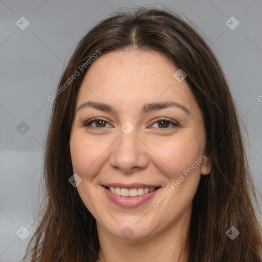 Joyful white adult female with long  brown hair and brown eyes