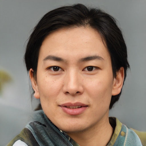 Joyful asian adult male with medium  brown hair and brown eyes