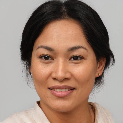 Joyful asian adult female with medium  brown hair and brown eyes