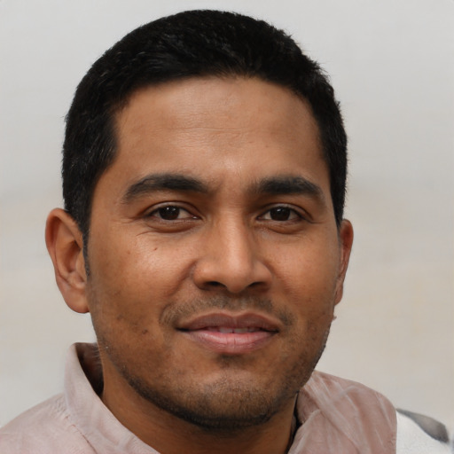 Joyful latino young-adult male with short  black hair and brown eyes
