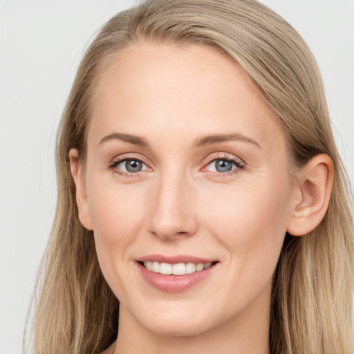 Joyful white young-adult female with long  brown hair and blue eyes