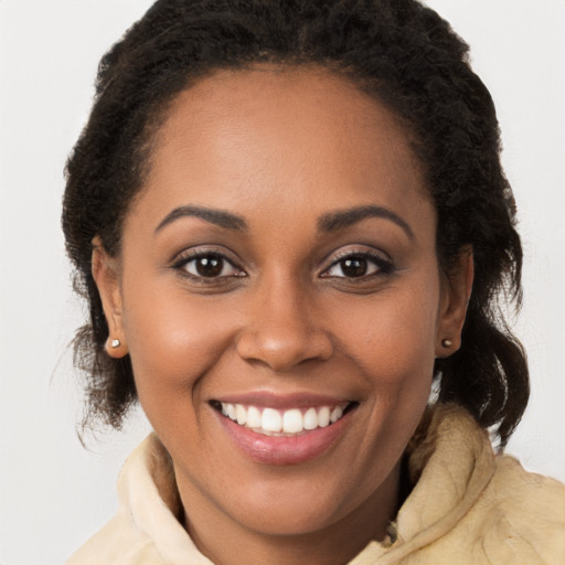 Joyful black young-adult female with long  brown hair and brown eyes