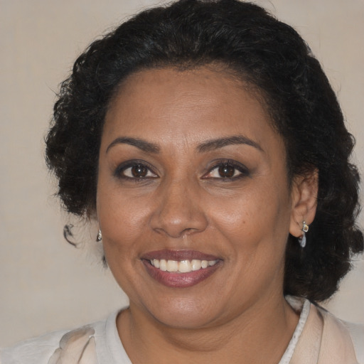 Joyful black adult female with medium  brown hair and brown eyes