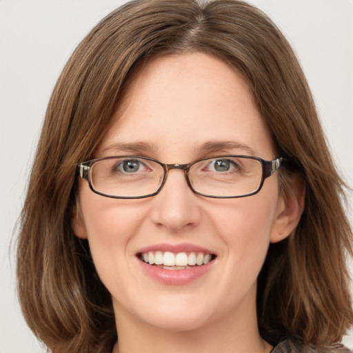 Joyful white adult female with medium  brown hair and green eyes