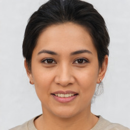 Joyful latino young-adult female with medium  brown hair and brown eyes