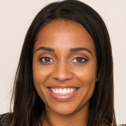 Joyful black young-adult female with long  brown hair and brown eyes