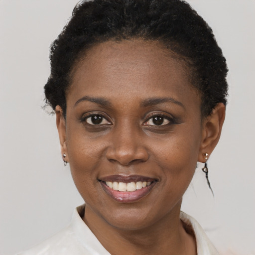 Joyful black young-adult female with short  black hair and brown eyes