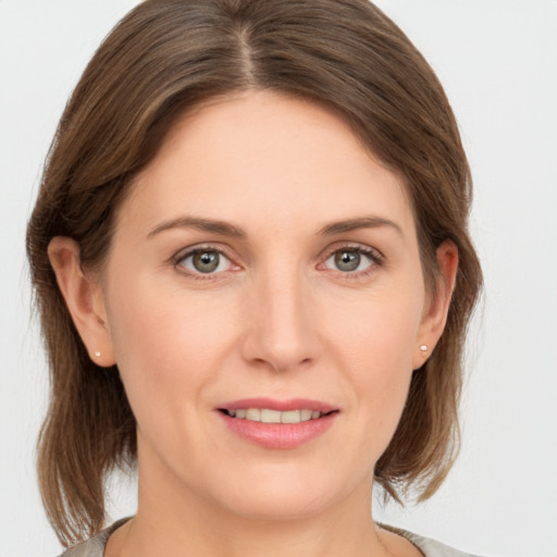 Joyful white young-adult female with medium  brown hair and grey eyes