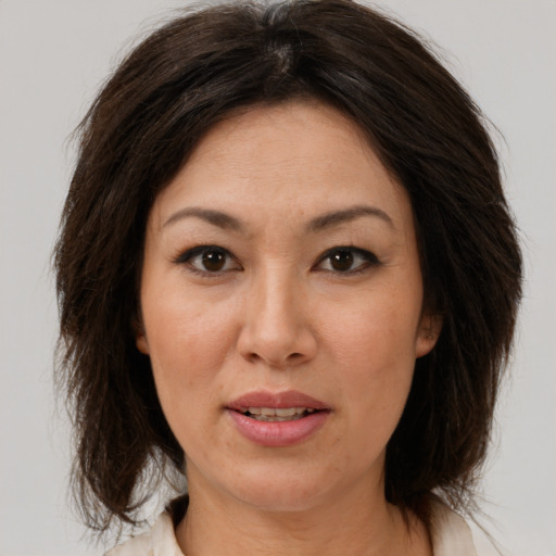 Joyful white adult female with medium  brown hair and brown eyes