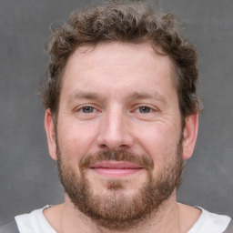 Joyful white adult male with short  brown hair and grey eyes