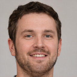 Joyful white adult male with short  brown hair and grey eyes