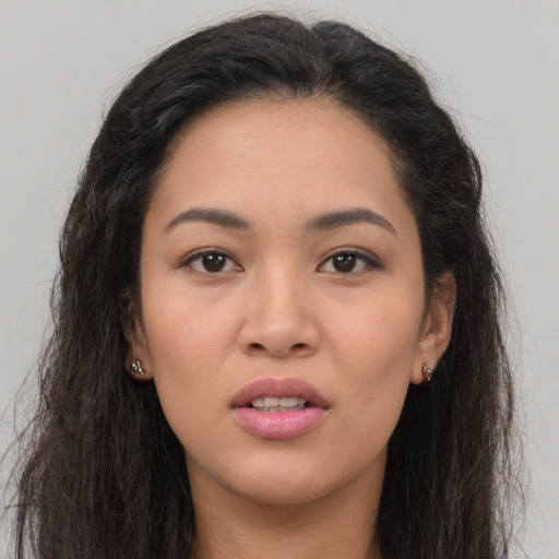 Joyful asian young-adult female with long  brown hair and brown eyes