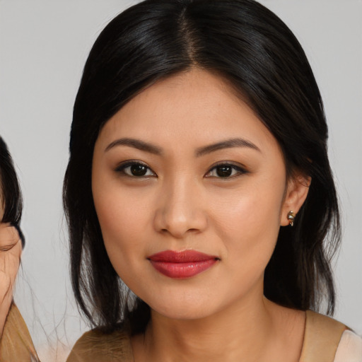 Joyful asian young-adult female with medium  brown hair and brown eyes