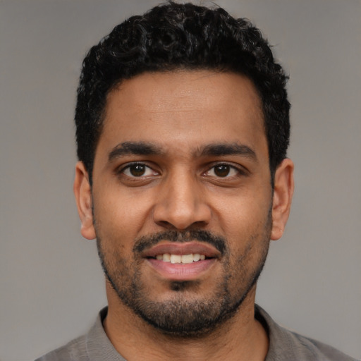 Joyful latino young-adult male with short  black hair and brown eyes