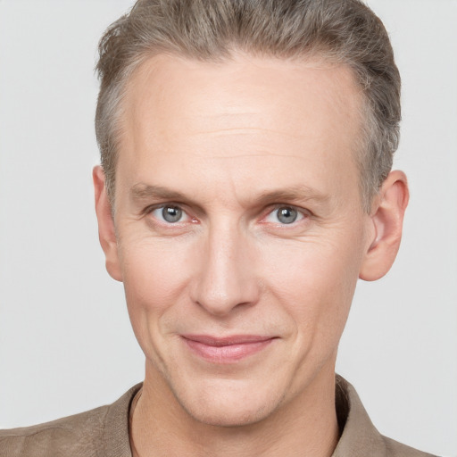 Joyful white adult male with short  brown hair and grey eyes