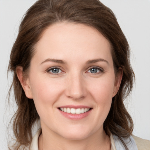 Joyful white young-adult female with medium  brown hair and grey eyes