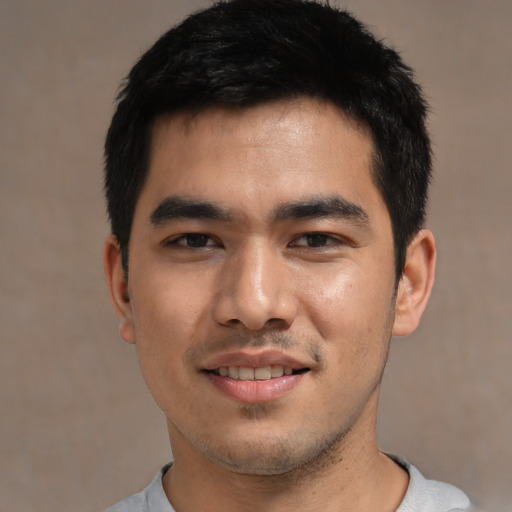 Joyful asian young-adult male with short  black hair and brown eyes