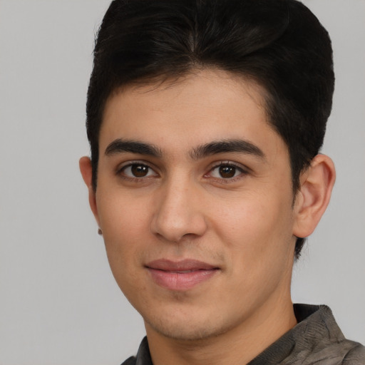 Joyful latino young-adult male with short  brown hair and brown eyes
