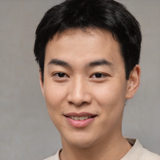 Joyful asian young-adult male with short  black hair and brown eyes