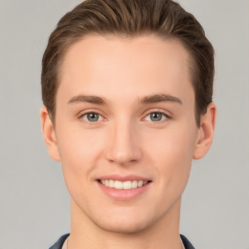 Joyful white young-adult male with short  brown hair and grey eyes