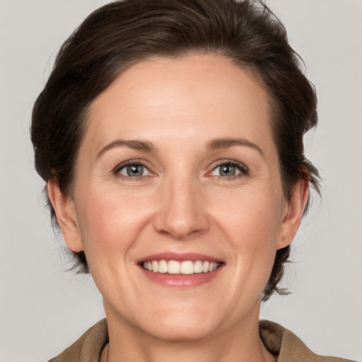 Joyful white adult female with medium  brown hair and grey eyes