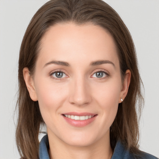 Joyful white young-adult female with medium  brown hair and grey eyes