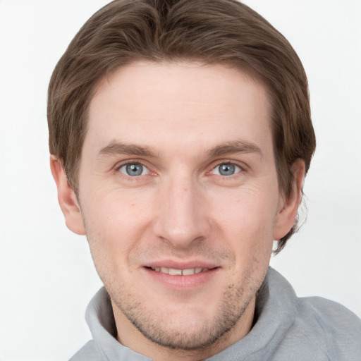 Joyful white young-adult male with short  brown hair and grey eyes