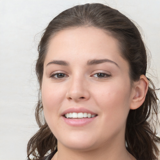 Joyful white young-adult female with medium  brown hair and grey eyes