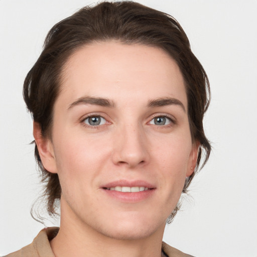 Joyful white young-adult female with medium  brown hair and grey eyes