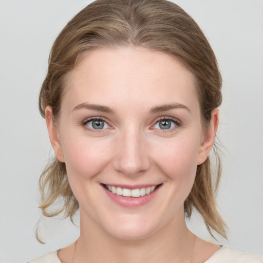 Joyful white young-adult female with medium  brown hair and blue eyes