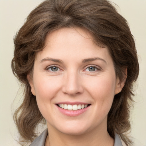 Joyful white young-adult female with medium  brown hair and green eyes