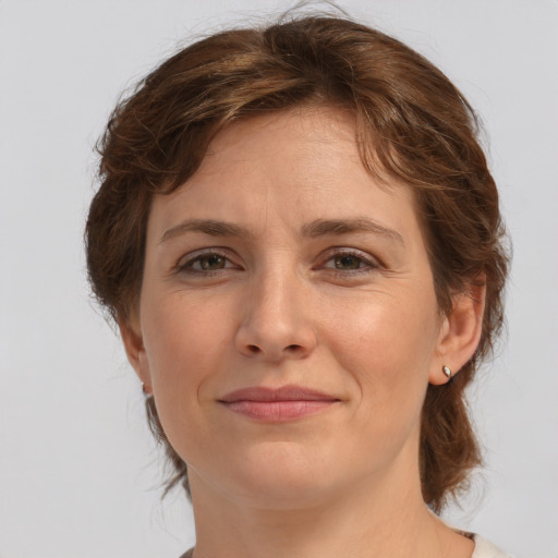 Joyful white young-adult female with medium  brown hair and green eyes