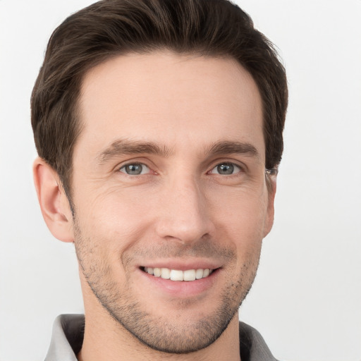 Joyful white young-adult male with short  brown hair and grey eyes