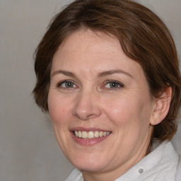 Joyful white adult female with medium  brown hair and grey eyes