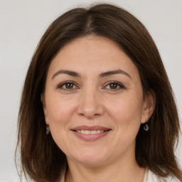 Joyful white adult female with long  brown hair and brown eyes